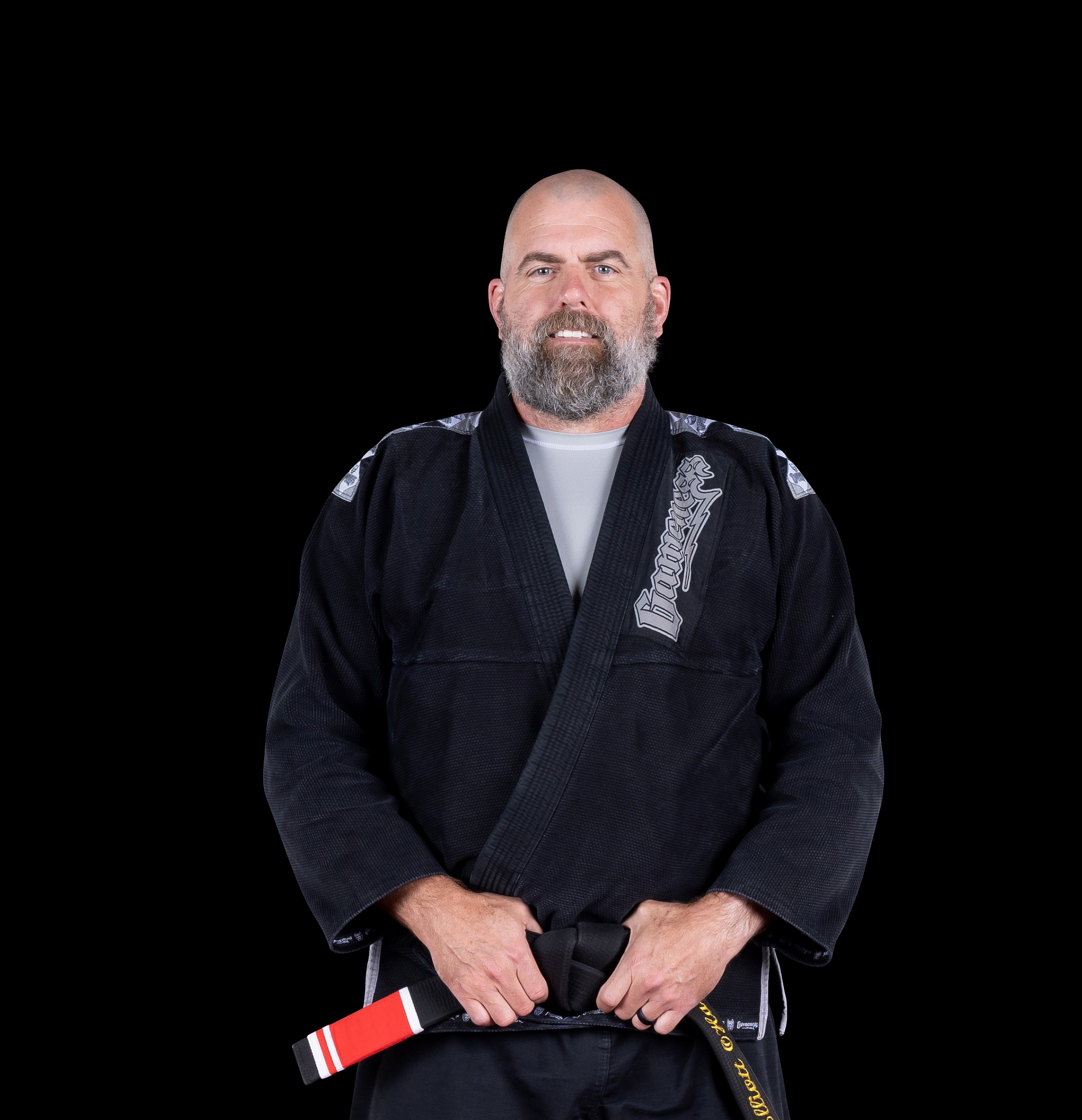 Elliott O'Hara in a black gi, holding his black belt